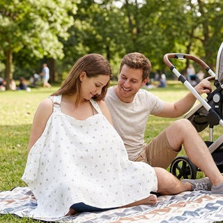 Univers Nest nursing cover cape providing privacy and comfort for breastfeeding, draped over a mother and baby.
