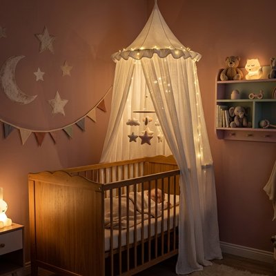 Baby bed canopy by Univers Nest, Magical Cocoon, hanging over a crib with soft, airy fabric for a cozy nursery ambiance.