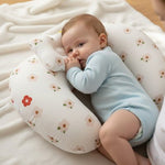 Ergonomic nursing pillow by Univers Nest showing a mother comfortably breastfeeding her baby. Soft, supportive design for mom and baby.