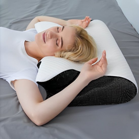 Ergonomic pillow by Univers Nest with contoured design for neck support and comfort, shown in a neutral fabric.